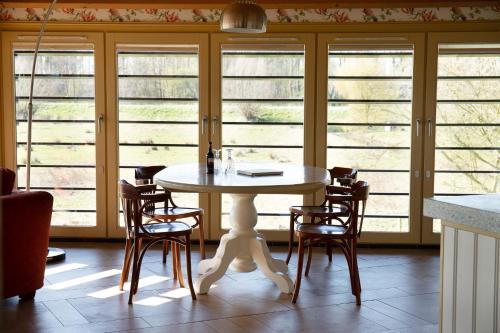 a table and chairs in a room with windows at Boerenhofstede de Overhorn in Weesp