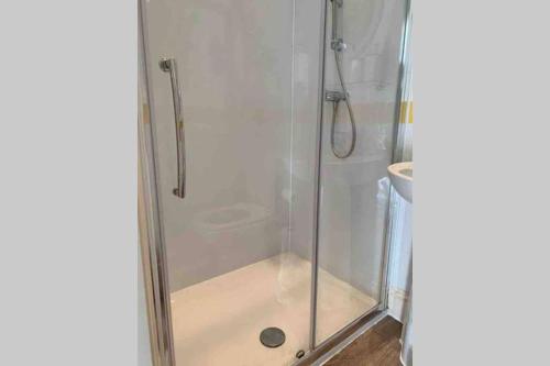 eine Dusche mit Glastür neben einer Toilette in der Unterkunft Eyemouth Home by the Harbour in Eyemouth