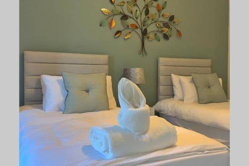 ein Schlafzimmer mit zwei Betten mit weißer Bettwäsche in der Unterkunft Eyemouth Home by the Harbour in Eyemouth