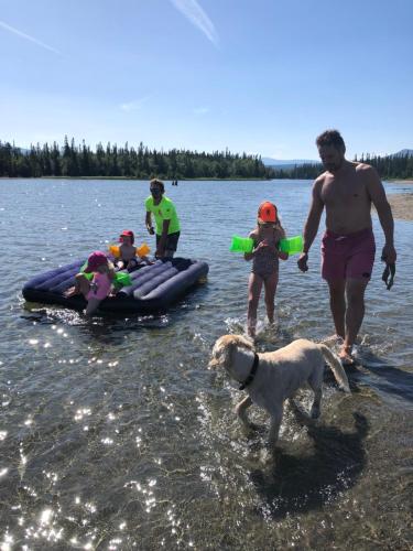 a group of people and a dog in the water at Vålågårdens Värdshus och Camping AB in Vålådalen