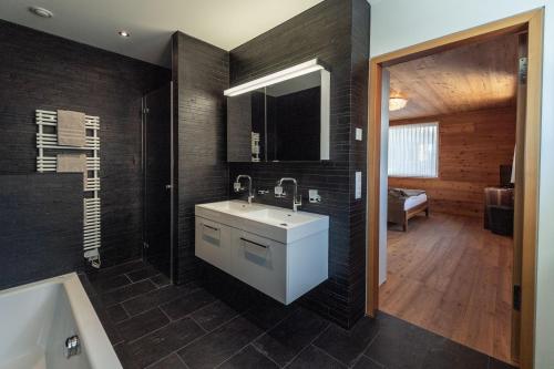 a bathroom with a sink and a bath tub at Andermatt Alpine Apartments in Andermatt