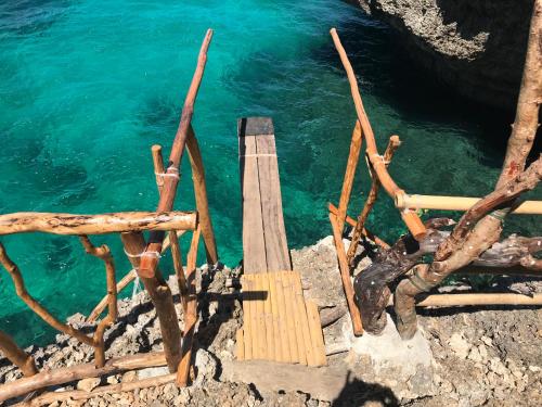a wooden staircase next to a body of water at The Beach House Carabao Island in San Jose