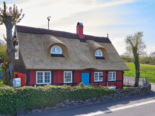 スヴァネケにある5 person holiday home in Svanekeの茅葺き屋根の赤い家