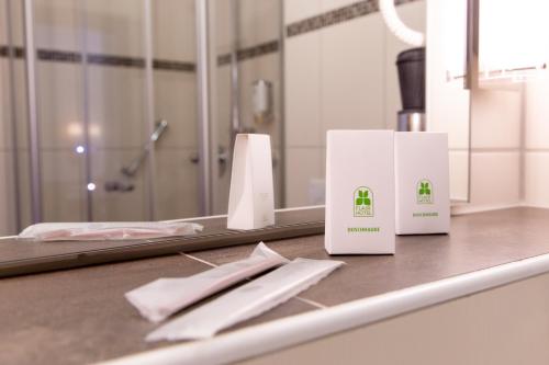 eine Badezimmertheke mit zwei weißen Schachteln darauf in der Unterkunft Flair Hotel Deutsches Haus in Arendsee