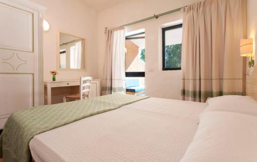 1 dormitorio con 2 camas, escritorio y ventana en Camping Village Capo D'Orso, en Palau