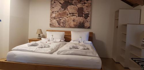 un letto con lenzuola bianche e asciugamani di Easy-Living Apartments Lindenstrasse 21 a Lucerna