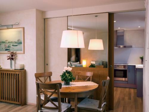 a kitchen and dining room with a table and chairs at Apartamentos la Torreta del Llac in Puigcerdà