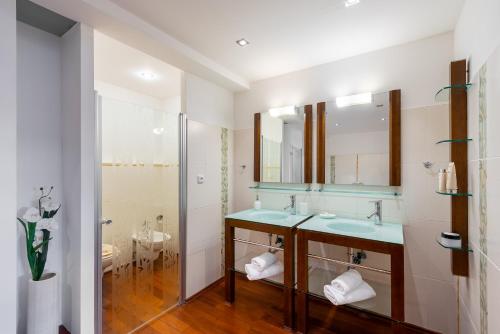 a bathroom with two sinks and a shower at Apartments Almandine in Prague