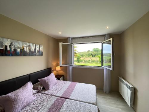 a bedroom with a bed and a window at Apartamentos La Ardina Celorio in Celorio