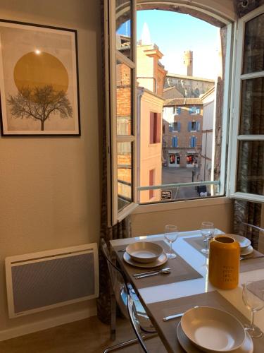 a dining table with a view of a window at Cathédrale Appart in Albi