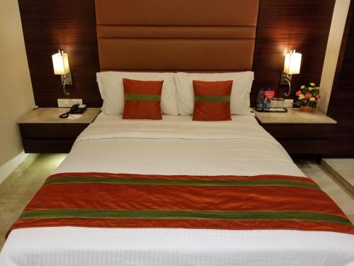 a large bed in a hotel room with two tables at The Samilton in Kolkata