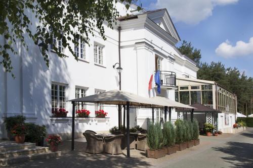 a white building with an umbrella in front of it at Klub Sosnowy in Warsaw