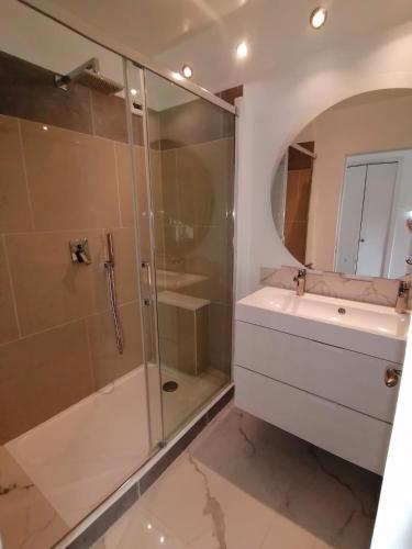 une salle de bain avec une douche en verre et un lavabo dans l'établissement Terrasse Vue Mer Plage à 50 m Parking, à Nice