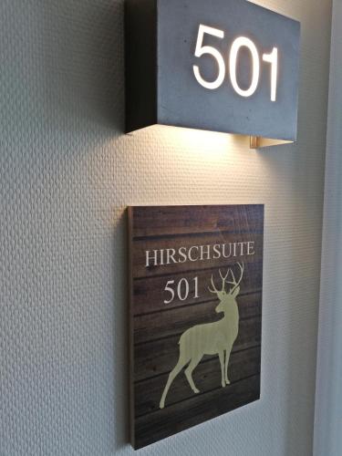 a sign on a wall with a deer on it at Hotel Rennsteig in Masserberg