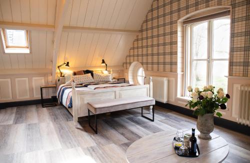 a bedroom with a bed and a table with flowers at Boerenhofstede de Overhorn in Weesp