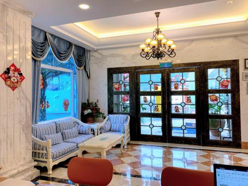 a living room with two couches and a chandelier at Hotel Bayview in Dahan