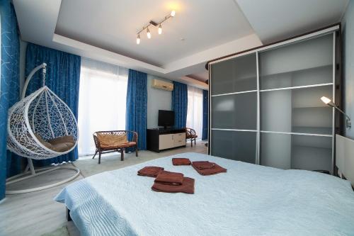 a bedroom with a large bed with two robes on it at Ай Сафия Hotel in Sudak