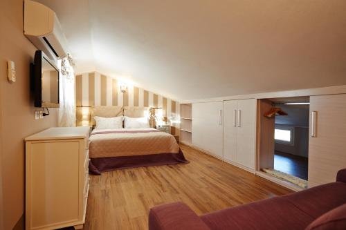 Holiday home with exclusive swimming pool in the Tuscan Maremma في Montemassi: غرفة نوم كبيرة مع سرير وأريكة