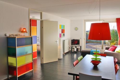 sala de estar con mesa y habitación colorida en Duinerei 2, en Callantsoog