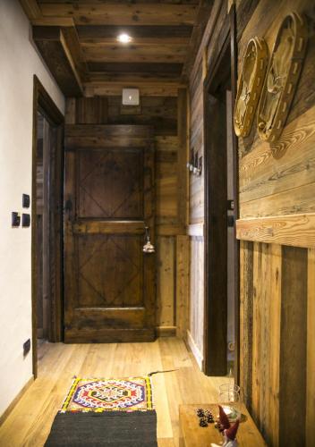 a hallway with a wooden door and a rug at Le Parfum du Sel in Aosta