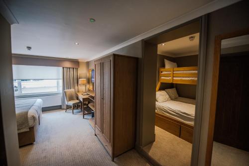 a hotel room with a bunk bed and a desk at Bowfield Hotel and Spa in Howwood