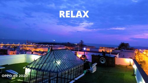a view of a city at night with the words relax at Lion Hostel By Rebels kiteschool in Tarifa