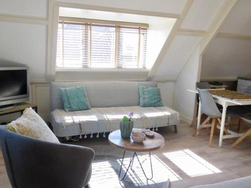 a living room with a couch and a table at Casa duna close to the beach, city centre, dunes and parking area in Zandvoort