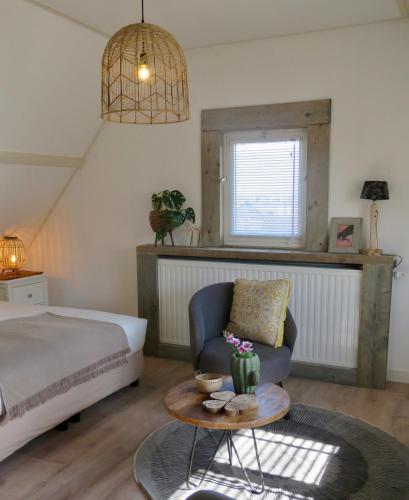 a bedroom with a bed and a chair and a table at Casa duna close to the beach, city centre, dunes and parking area in Zandvoort