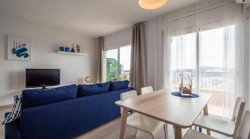 Bed&Bcn Glories في برشلونة: غرفة معيشة مع أريكة زرقاء وطاولة