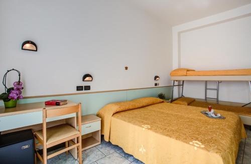 een slaapkamer met een bed, een bureau en een stapelbed bij Hotel Ondina in Cattolica