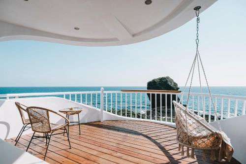 balkon z 2 krzesłami i stołem oraz ocean w obiekcie Yellow's Kenting B&B II w mieście Eluan
