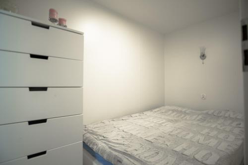 克里尼查謨爾斯卡的住宿－Maximus domki，一间白色卧室,配有一张床和一个梳妆台