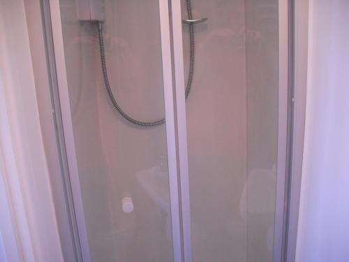 a shower with a glass door with a hose at White Horse Studio in Preston