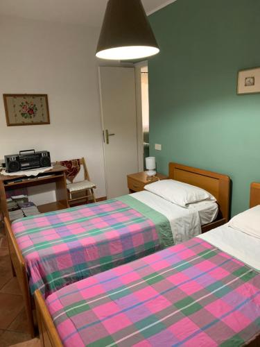 サン・ジョルジョにあるMini Villetta San Giorgioのベッドルーム1室(ベッド2台、デスク付)