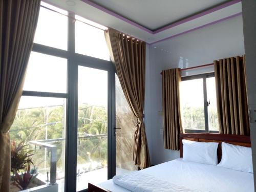 a bedroom with a bed and a large window at Hướng Dương Hotel Đảo Phú Quý in Phú Quý