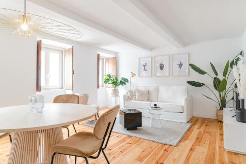 een witte woonkamer met een tafel en stoelen bij Casa Boma Lisboa - Charming and Typical Apartment - Lapa III in Lissabon