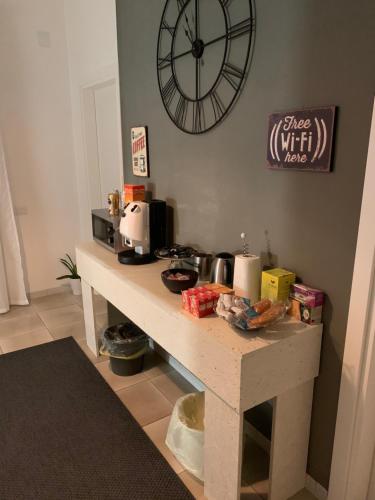 ein Tisch mit einer Kaffeemaschine und einer Uhr an der Wand in der Unterkunft La Villetta B&B in Scisciano