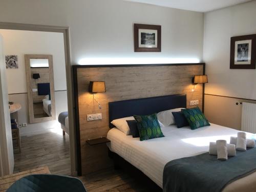 a hotel room with two beds and a mirror at Hôtel Saint Albert in Sarlat-la-Canéda