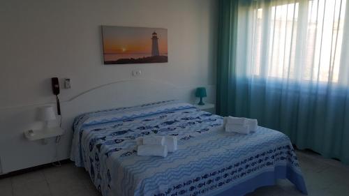 a bedroom with a bed with a lighthouse on the wall at Hotel VILLA ITALIA B&B in Porto Azzurro