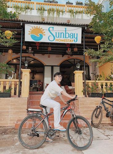 a man riding a bike in front of a restaurant at Sunbay Homestay Cu Lao Cham in Tân Hiệp