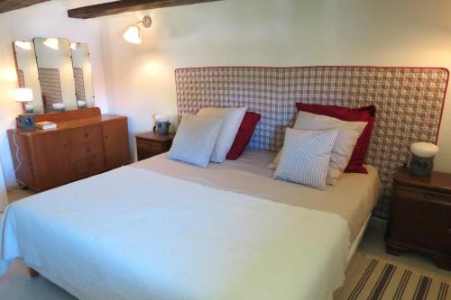 1 dormitorio con 1 cama grande con almohadas rojas y blancas en MORTZI villa 4 étoiles avec piscine, en Mortzwiller