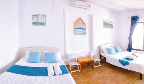 a bedroom with two beds with blue pillows at Sunbay Homestay Cu Lao Cham in Tân Hiệp