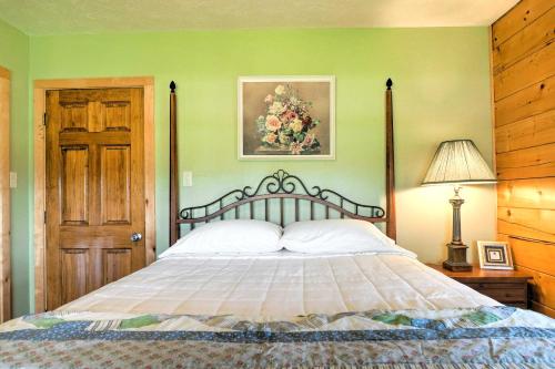 Un dormitorio con una cama y una pared verde. en On Farm Rustic Carmine Log Cabin with Porch!, en Carmine
