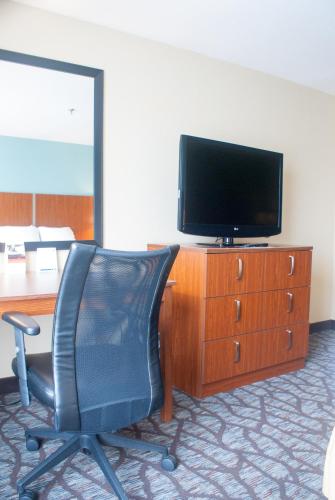 a desk with a chair and a television on a dresser at Holiday Inn Express & Suites Jacksonville South - I-295 by IHG in Jacksonville