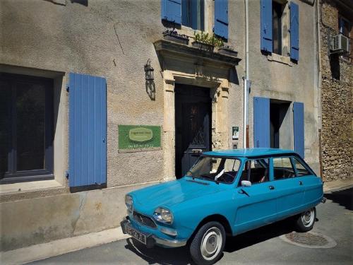 an old blue car parked in front of a building at Logement Onze Chambres & Gîtes in Raissac-dʼAude