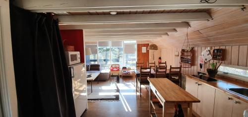 a kitchen and living room with a table and a dining room at Bard Cottage in Akranes