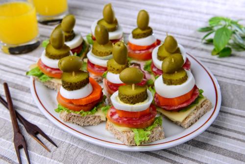 a plate of sandwiches with olives on top at Curi Palace Hotel in Pelotas