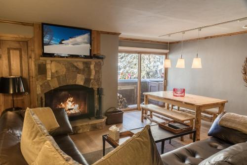 a living room with a fireplace with a tv on a wall at Lionshead Arcade by Vail Realty in Vail