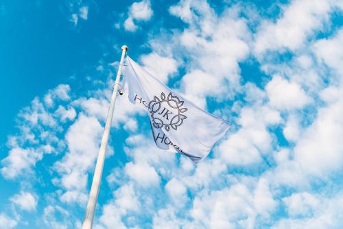 a white flag flying in the sky with clouds at Jūras Krasti Romantika in Jūrmalciems