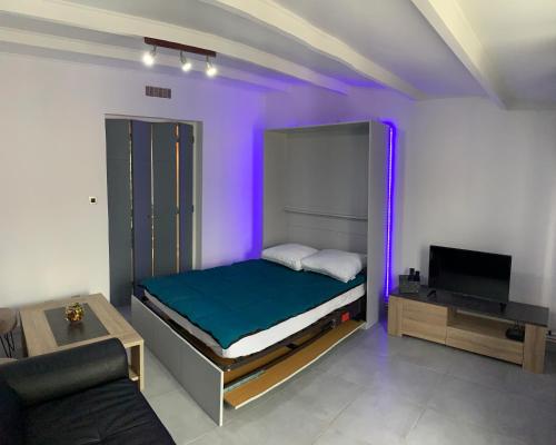a bedroom with a bed with purple lights on it at Le cabanon de bottai in Port-de-Bouc